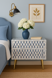 Nighstand with floral arrangement and lamp in bedroom setting