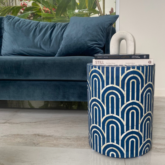 Blue patterned storage basket next to a blue sofa with books on top