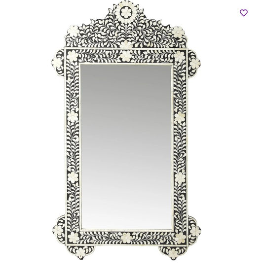 Decorative wall mirror with intricate black and white pattern on a white background