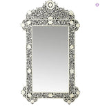 Decorative wall mirror with intricate black and white pattern on a white background