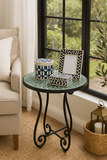 Small round table with decorative items in a living room setting