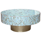 Round coffee table with a decorative top and brass base on a white background