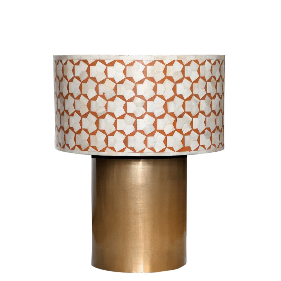 Decorative lamp with patterned shade and brass base on a white background