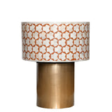 Decorative lamp with patterned shade and brass base on a white background