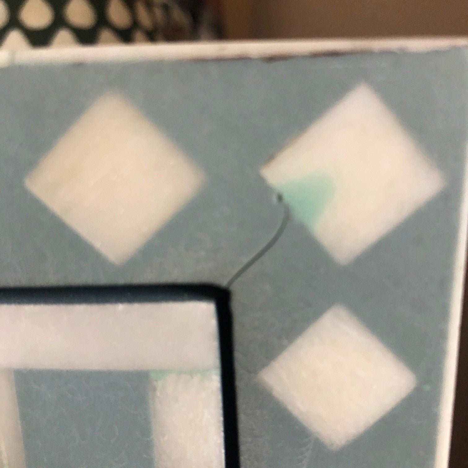 Close-up of a geometric pattern with diamond shapes on a textured surface.