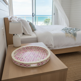 Decorative tray on a nightstand with a bed and ocean view in the background
