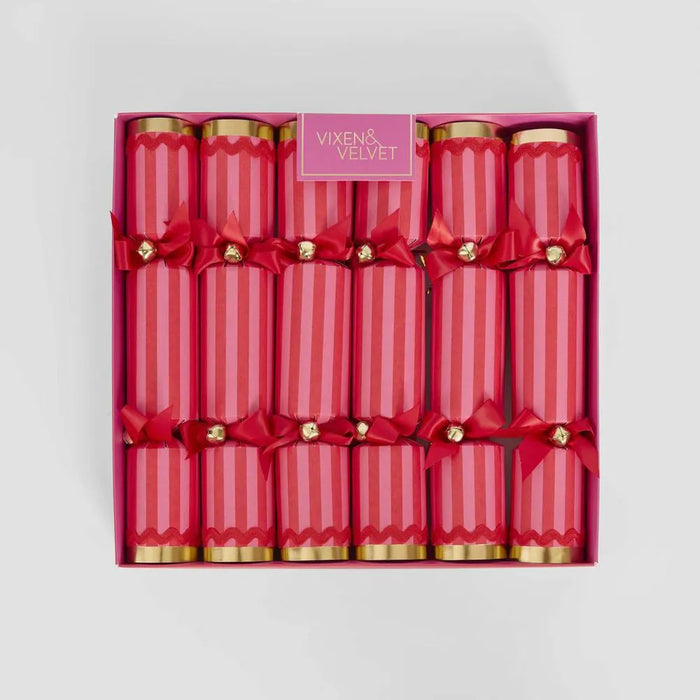 Box of red crackers with gold ends and red bows, branded 'Vixen & Velvet', on a light gray background.