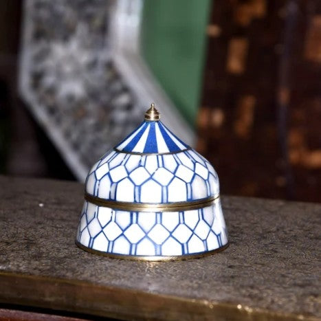 Decorative blue and white patterned box on a surface with a blurred background