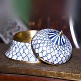 Decorative ceramic containers with blue and white geometric patterns on a wooden surface.