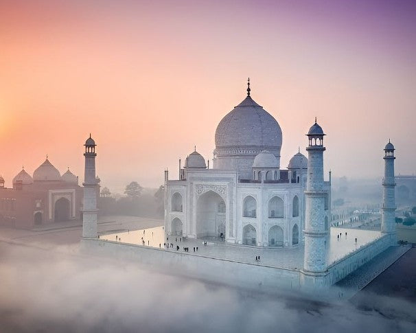 The Taj Mahal at sunrise with a soft pink sky